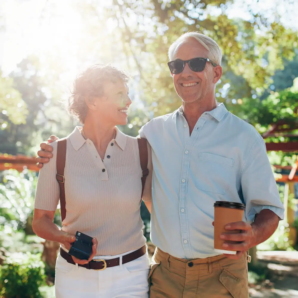 Happy retired couple walking in the sunshine — supported by Kauri Wealth’s personalised retirement and income planning Australia.